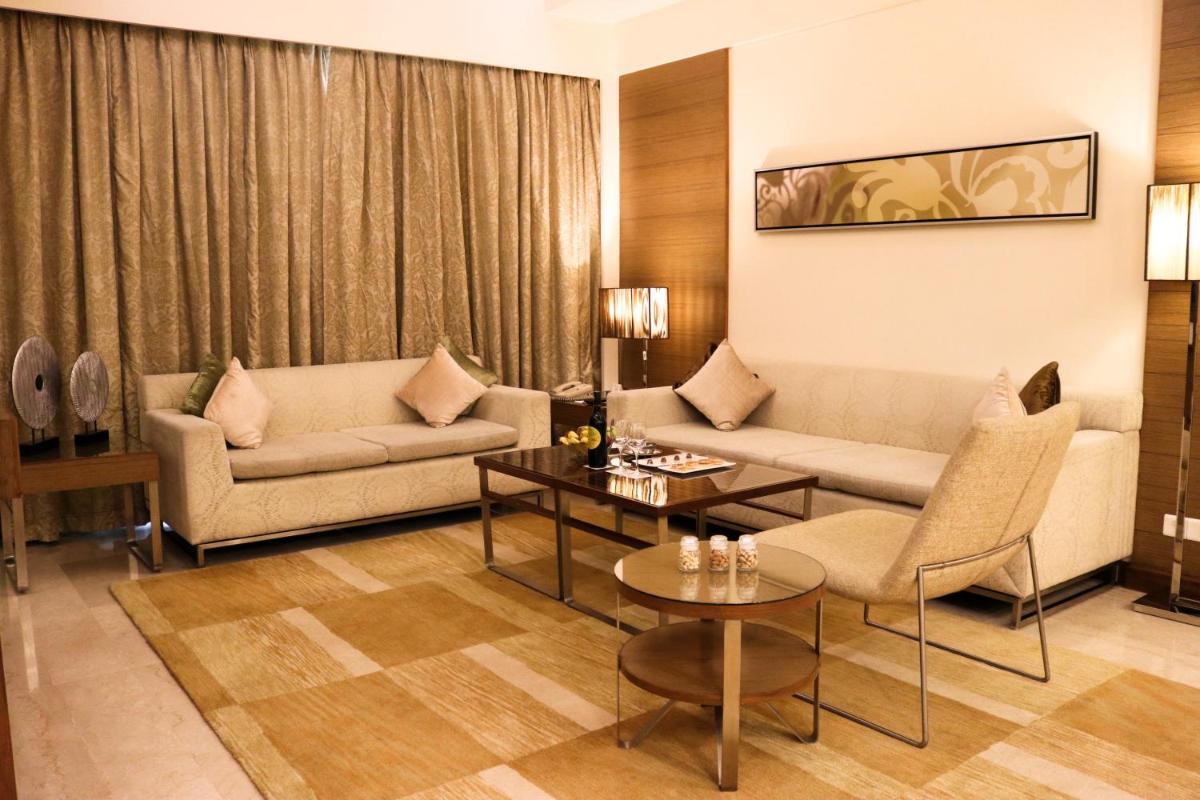a living room with two couches and a table at Radisson Blu Hotel, Greater Noida in Greater Noida