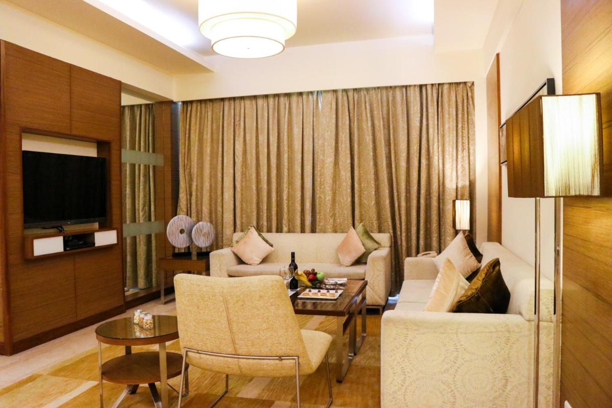 a living room with a couch and a table at Radisson Blu Hotel, Greater Noida in Greater Noida