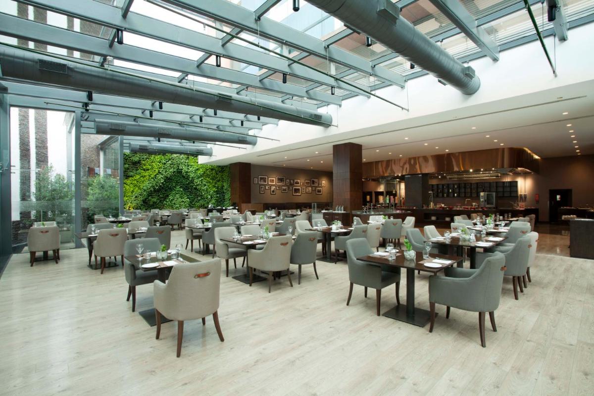 a dining room with tables and chairs in a restaurant at The Oterra in Bengaluru a dining room with tables and chairs in a restaurant at The Oterra in Bengaluru