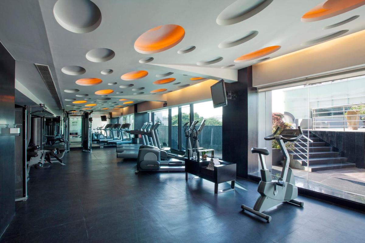 a gym with treadmills and elliptical machines at The Oterra in Bengaluru