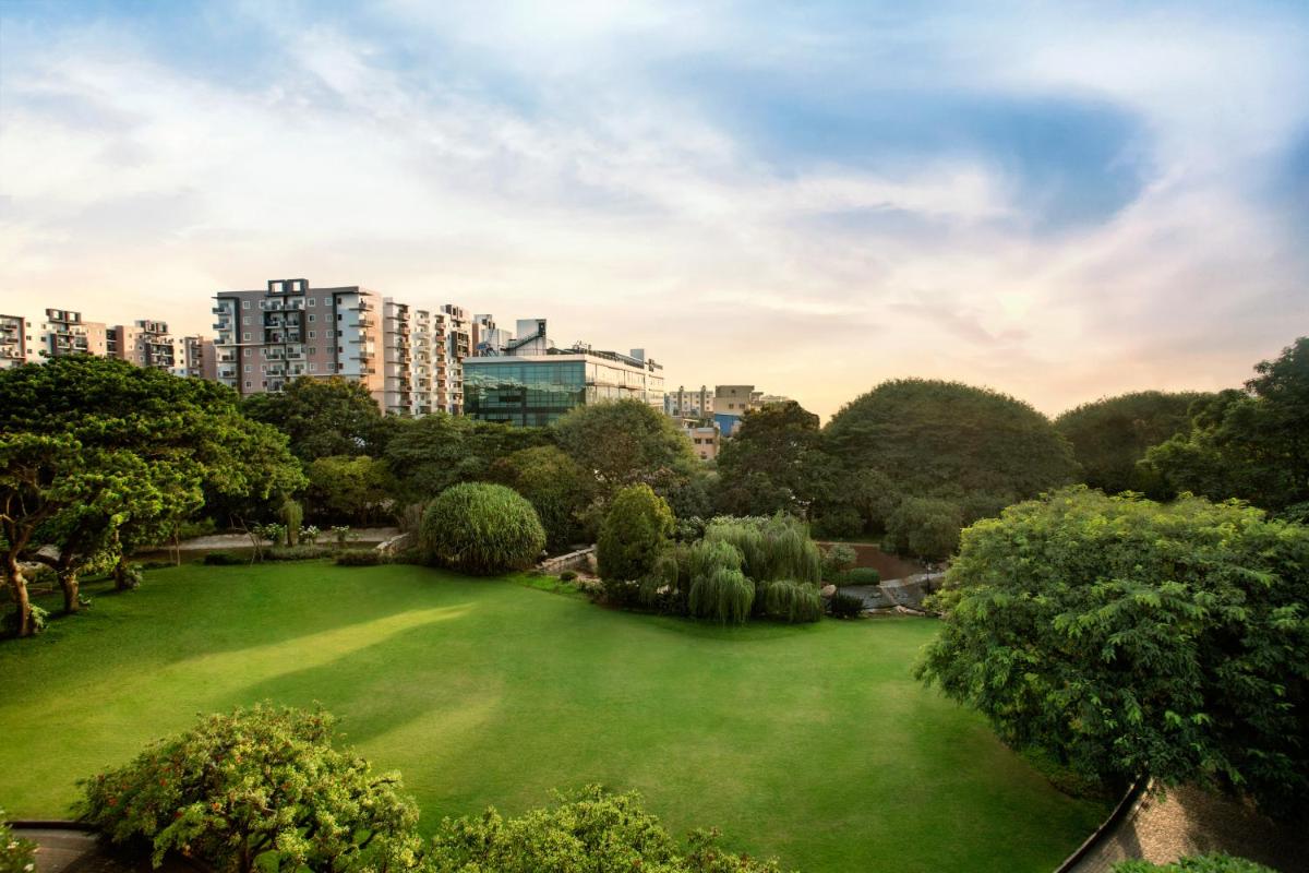 a large green park with buildings in the background at The Oterra in Bengaluru