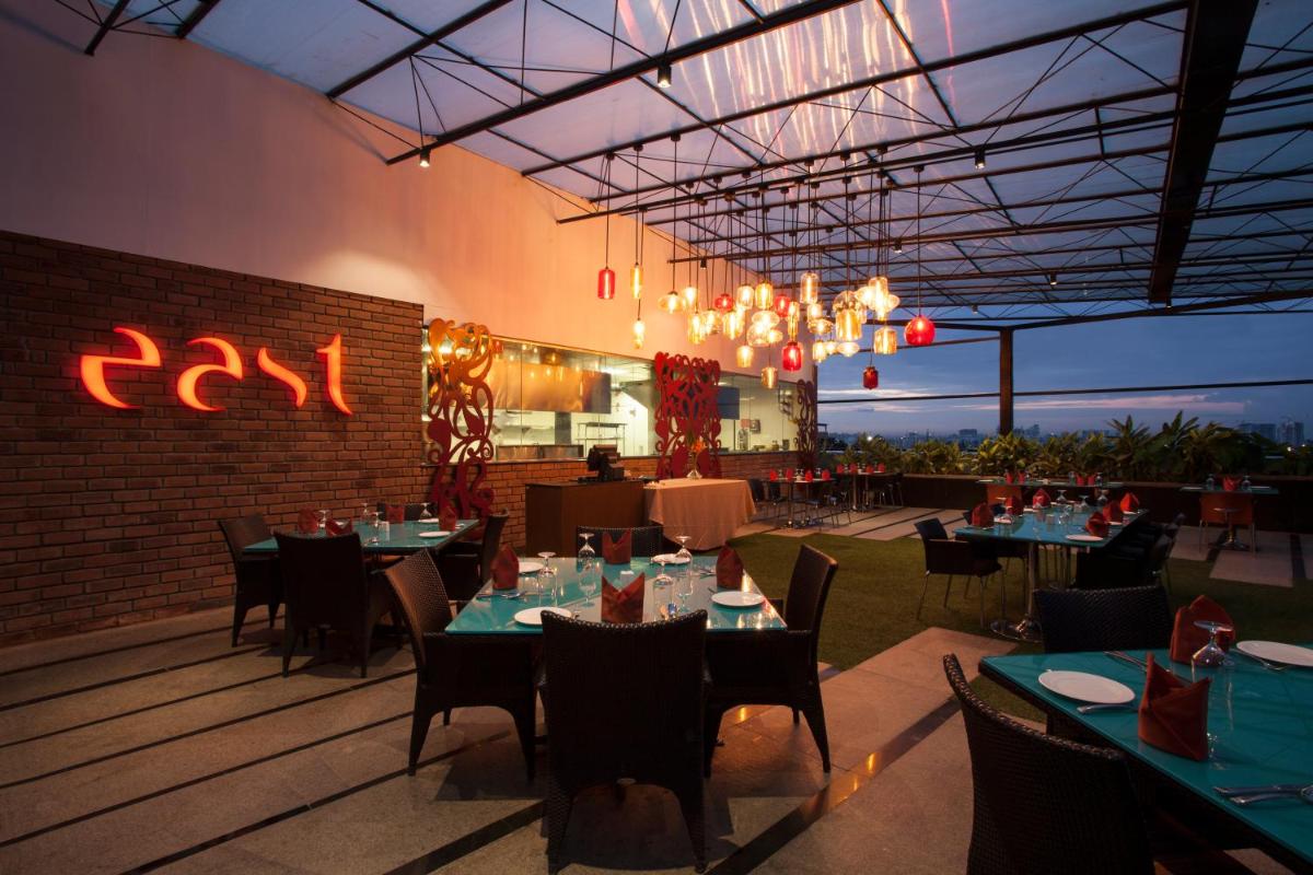 a dining room with tables and chairs and a restaurant at The Oterra in Bengaluru
