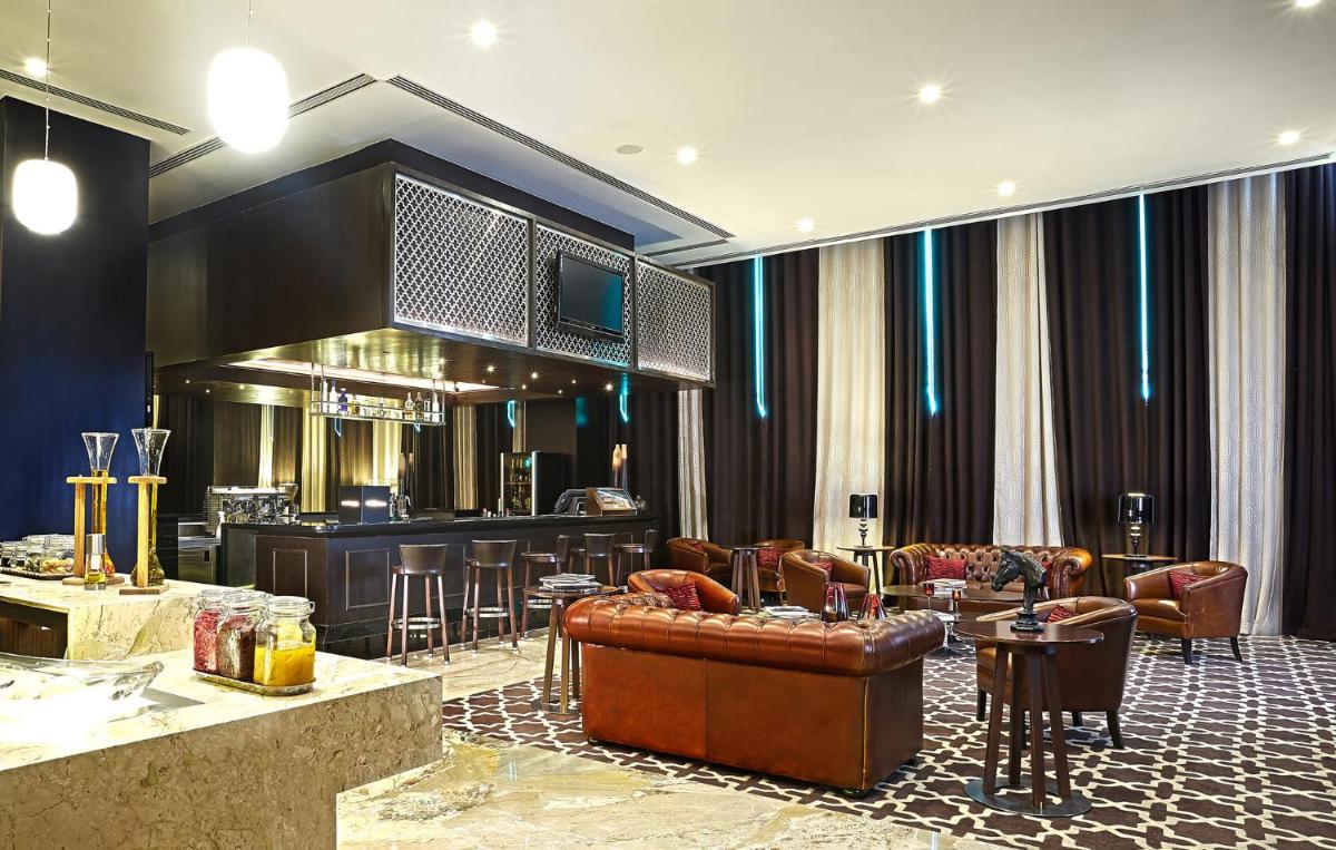 a living room with a couch and a bar at The Oterra in Bengaluru