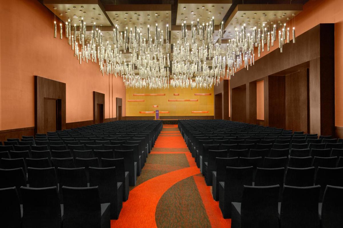 an empty hall with black chairs and chandeliers at The Oterra in Bengaluru