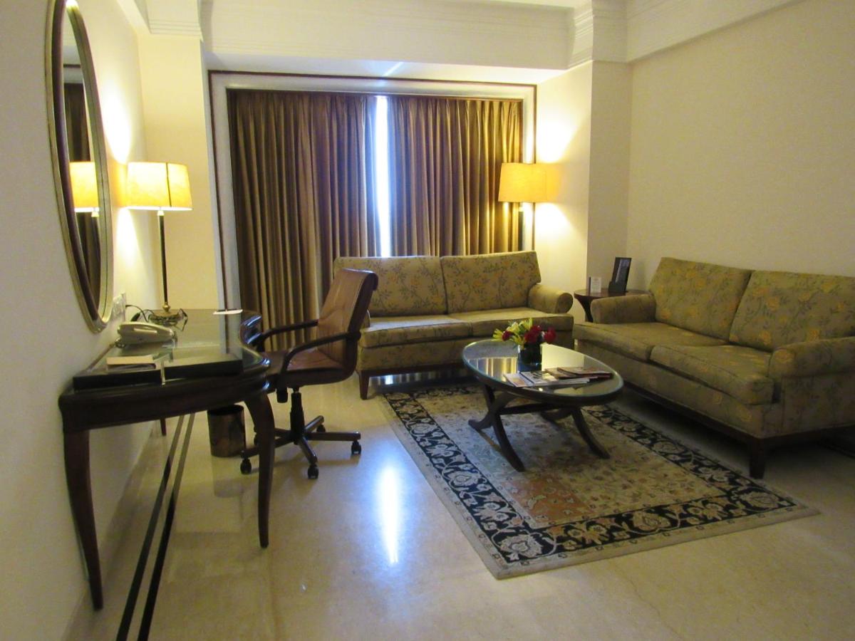 a living room with a couch and a table at Eros Hotel New Delhi, Nehru Place in New Delhi a living room with a couch and a table at Eros Hotel New Delhi, Nehru Place in New Delhi