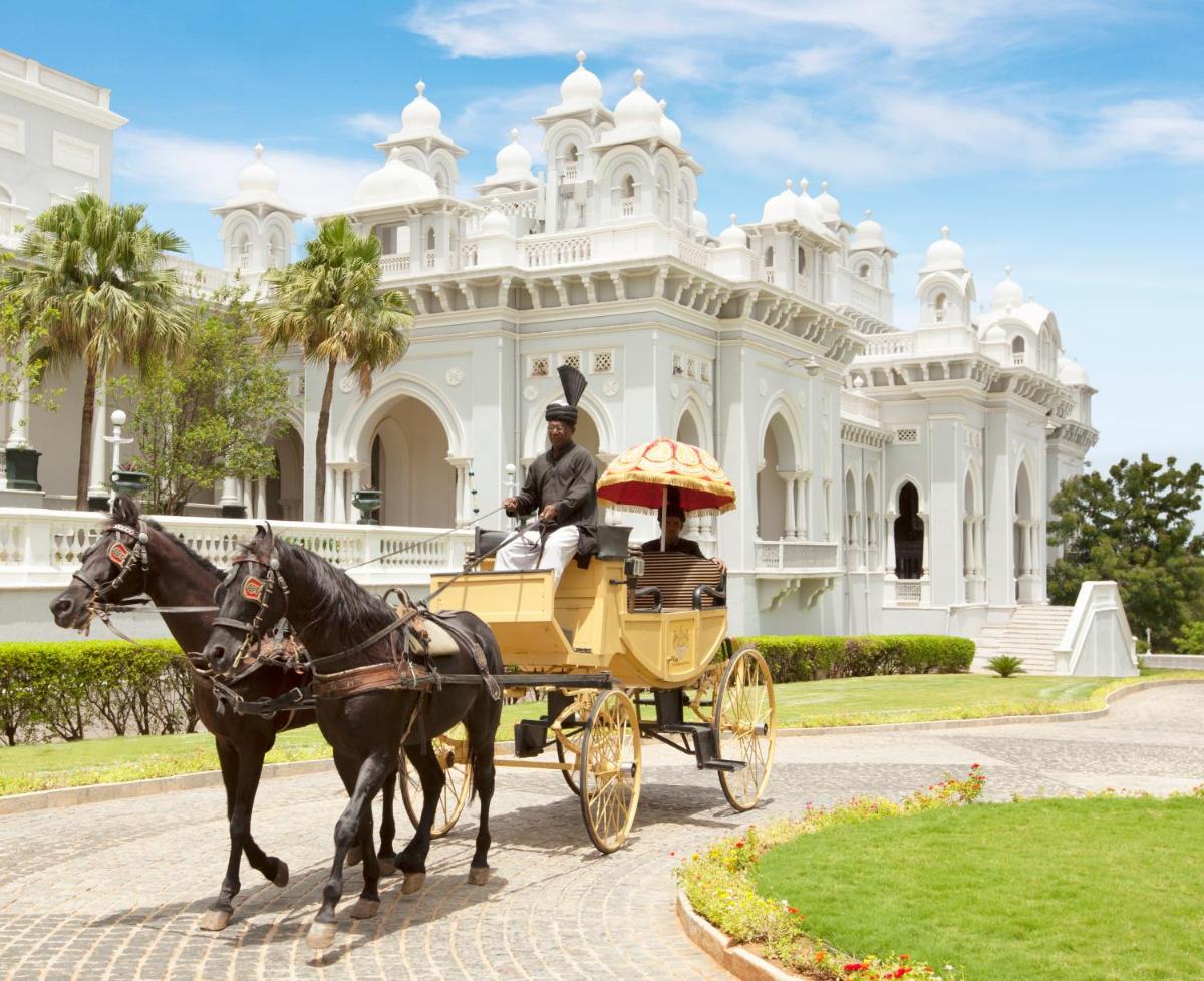 a man riding in a horse drawn carriage in front of a building at Taj Falaknuma Palace in Hyderabad