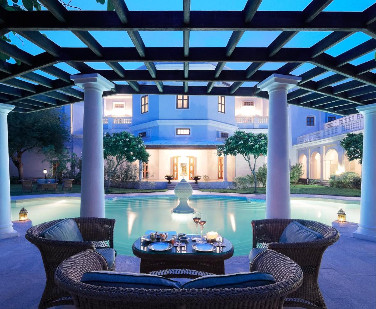 a patio with a table and chairs in front of a pool at Taj Falaknuma Palace in Hyderabad