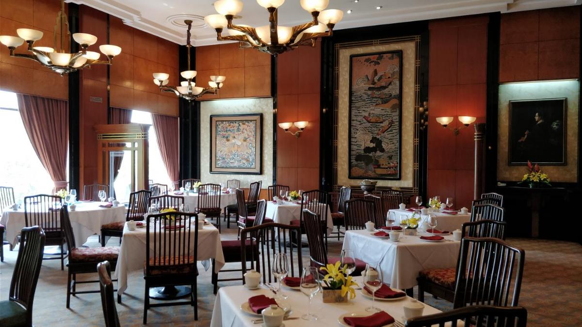 a dining room with white tables and chairs and chandeliers at Eros Hotel New Delhi, Nehru Place in New Delhi a dining room with white tables and chairs and chandeliers at Eros Hotel New Delhi, Nehru Place in New Delhi