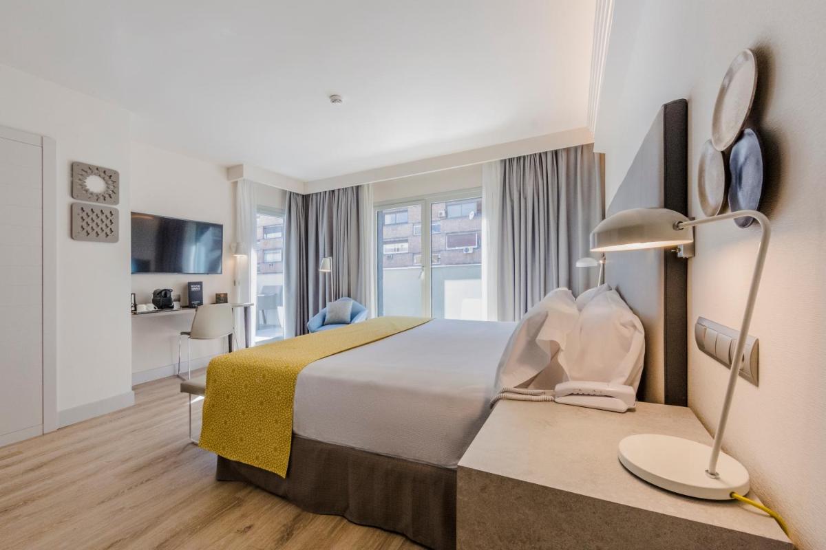 Una habitación de hotel con una cama grande y una ventana. en Catalonia Granada, en Granada