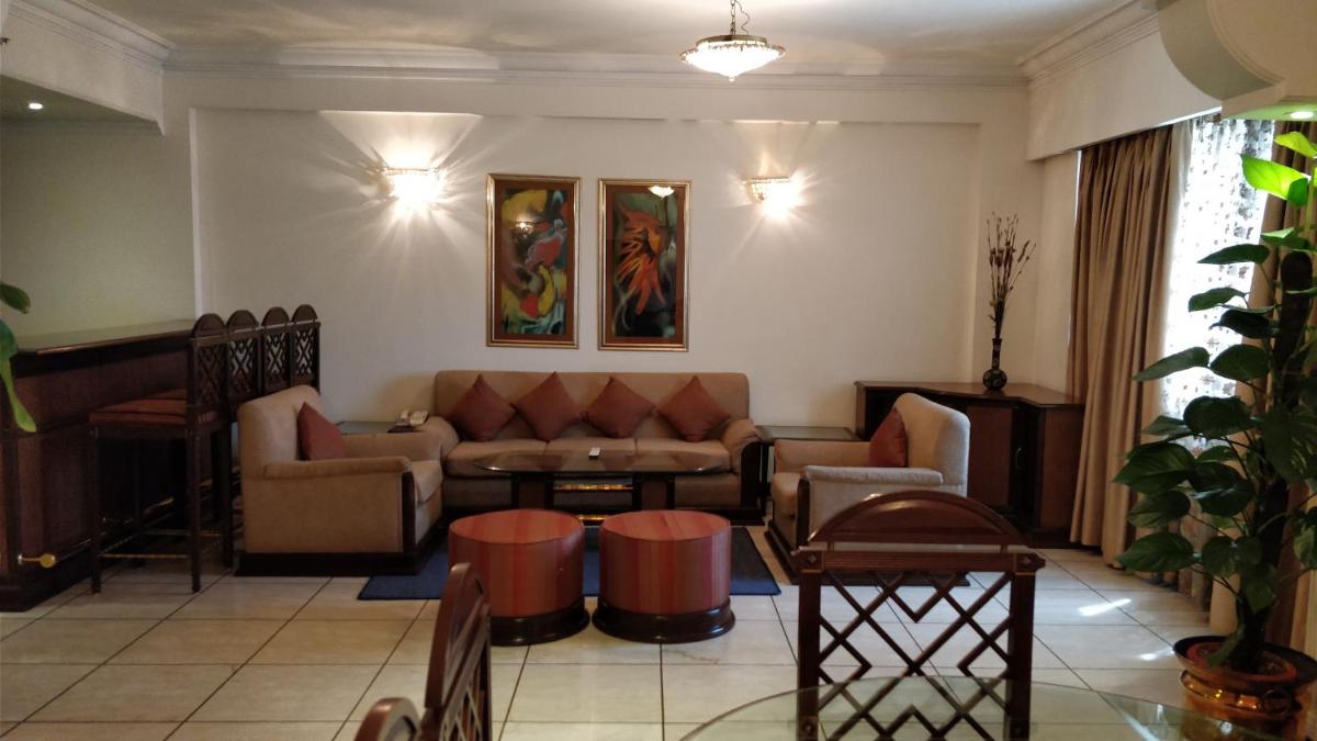 a living room with a couch and a table at The Suryaa New Delhi in New Delhi a living room with a couch and a table at The Suryaa New Delhi in New Delhi