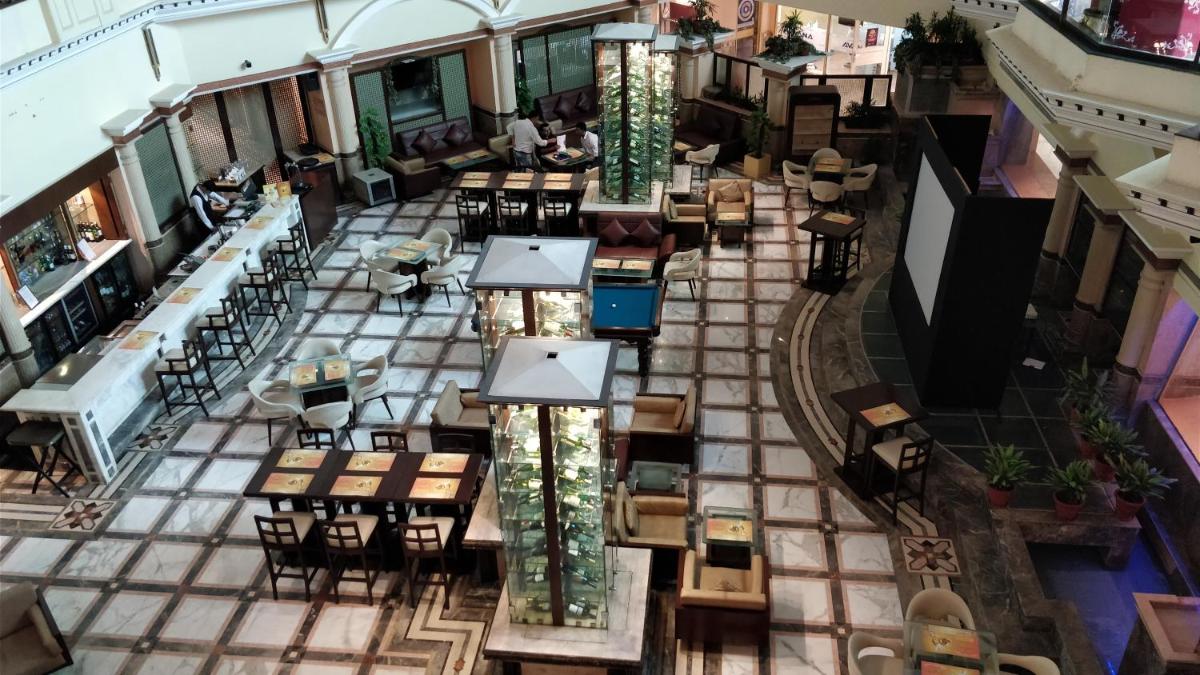 an overhead view of a restaurant with tables and chairs at The Suryaa New Delhi in New Delhi an overhead view of a restaurant with tables and chairs at The Suryaa New Delhi in New Delhi
