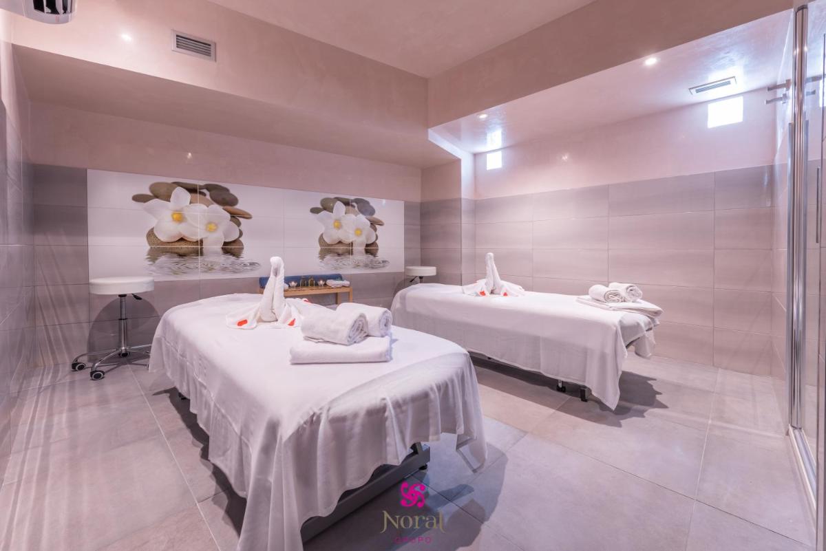 Una habitación de hospital con dos camas y ducha. en Hotel Norat Marina & Spa 4* Superior, en O Grove