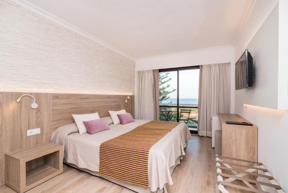 una habitación de hotel con una cama y un balcón en Hotel Na Taconera, en Cala Ratjada 65 fotos más