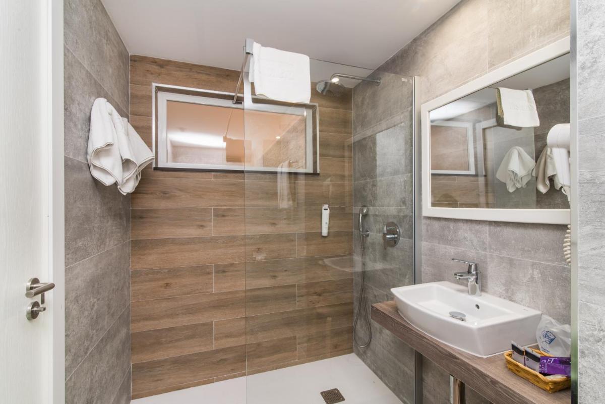 un baño con lavabo y espejo en Hotel Na Taconera, en Cala Ratjada
