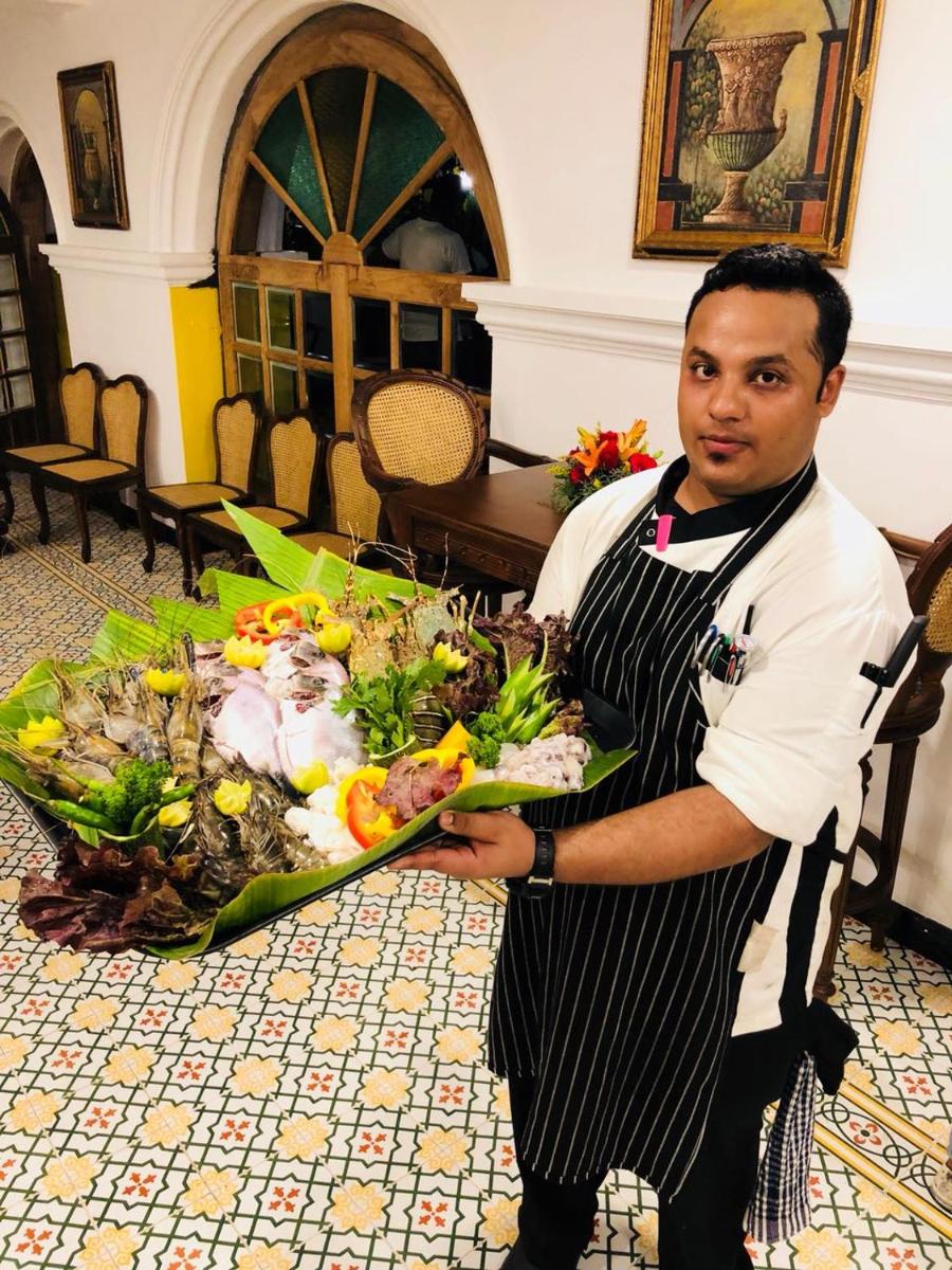 a man holding a large bouquet of flowers at Forte Kochi in Cochin