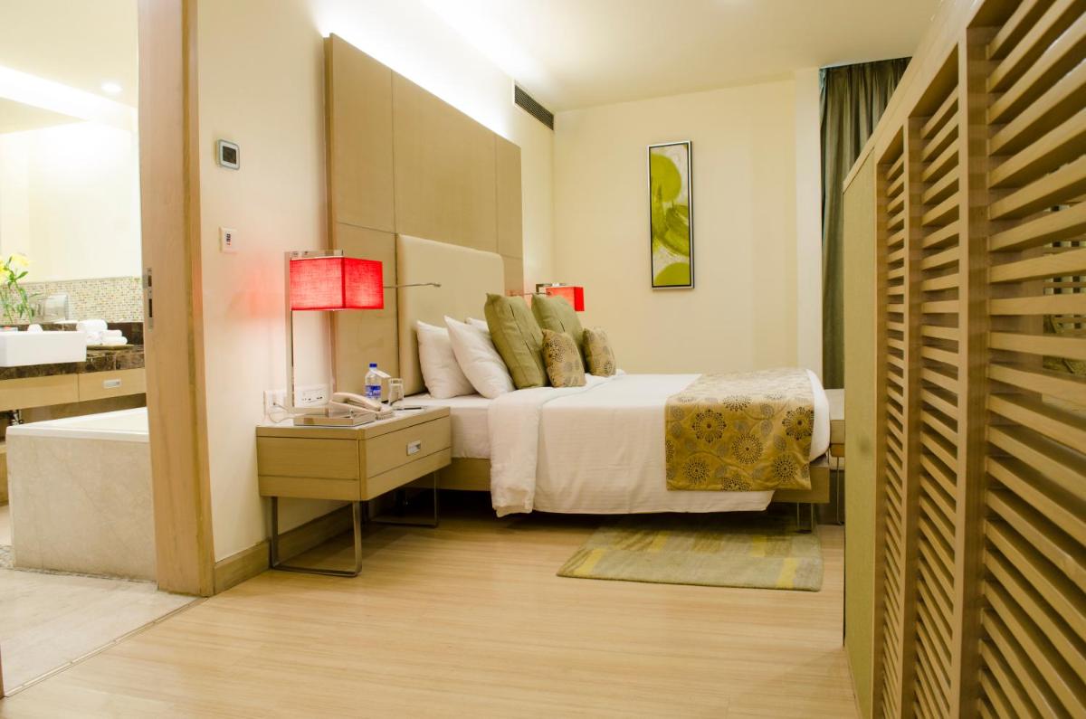 a hotel room with a bed and a bathroom at Radisson Blu Hotel, Greater Noida in Greater Noida