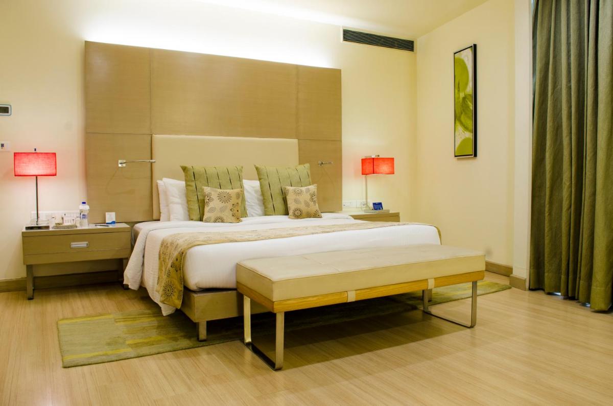 a bedroom with a large bed with a large headboard at Radisson Blu Hotel, Greater Noida in Greater Noida
