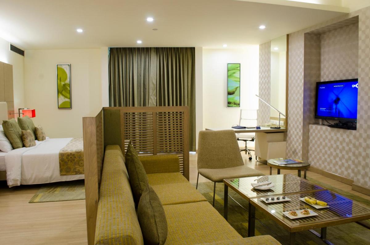 a hotel room with a bed and a living room at Radisson Blu Hotel, Greater Noida in Greater Noida