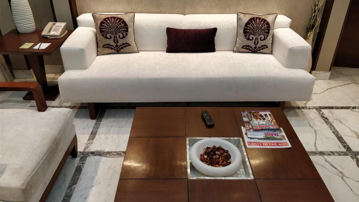 a living room with a white couch and a bowl of food at Jaypee Vasant Continental in New Delhi