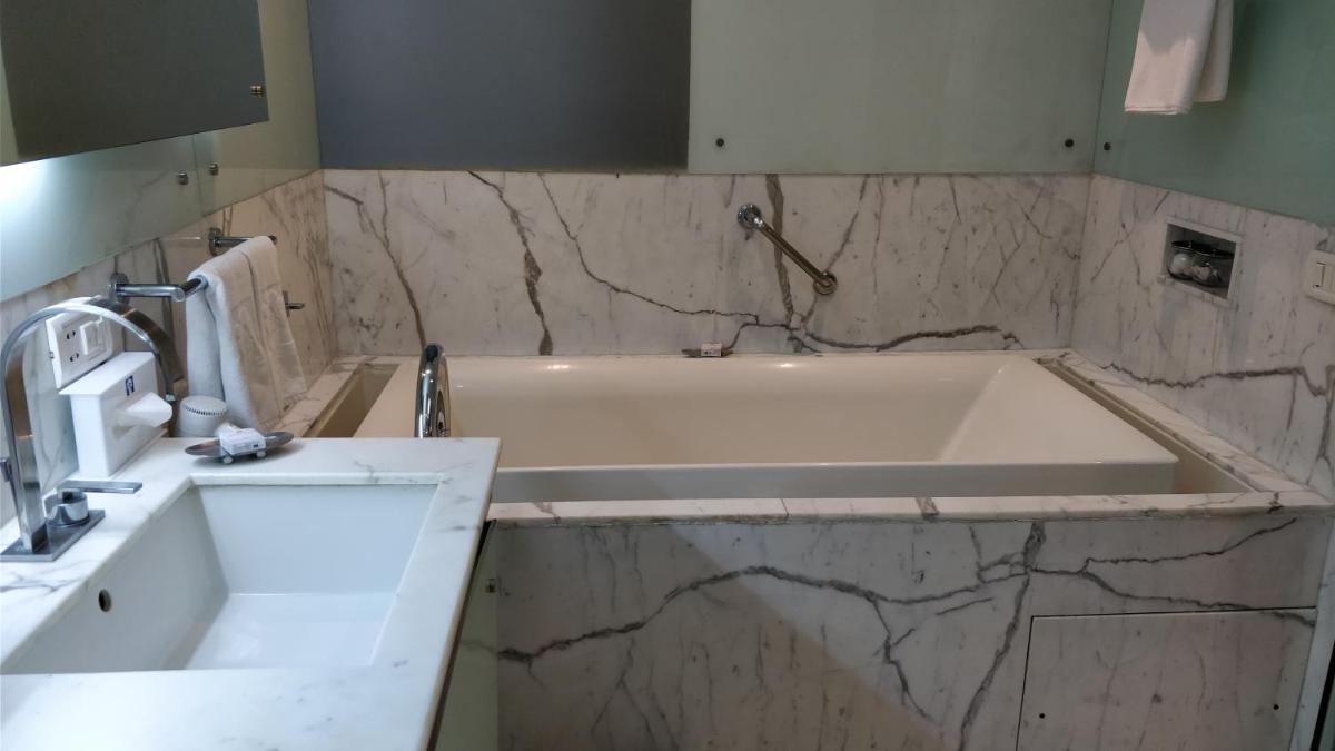 a bathroom with a tub and a sink at Jaypee Vasant Continental in New Delhi