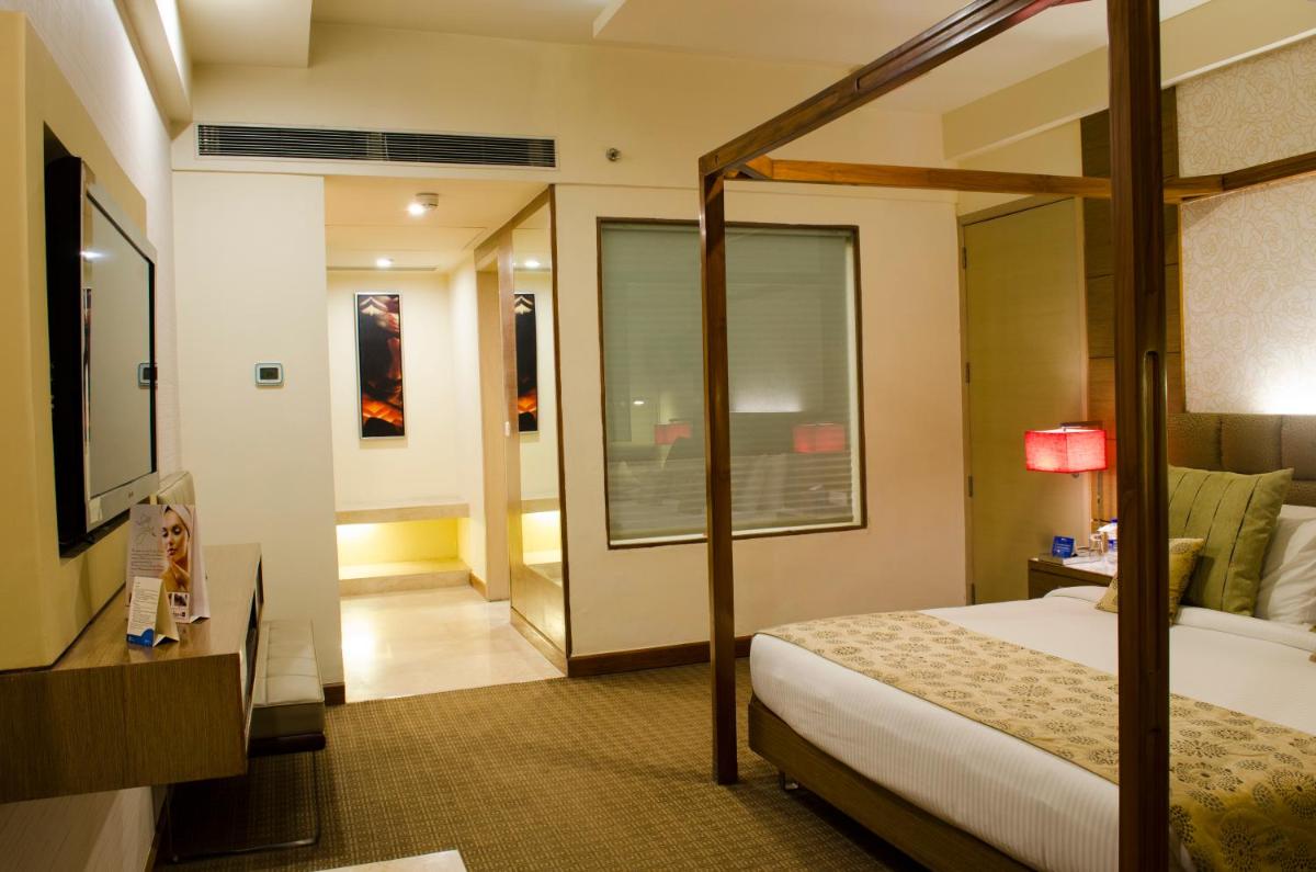 a hotel room with a bed and a mirror at Radisson Blu Hotel, Greater Noida in Greater Noida