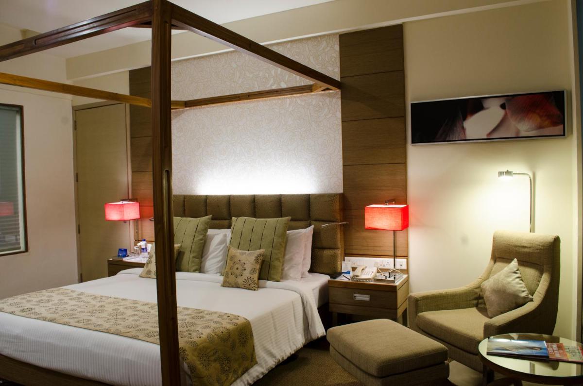 a hotel room with a bed and a chair at Radisson Blu Hotel, Greater Noida in Greater Noida