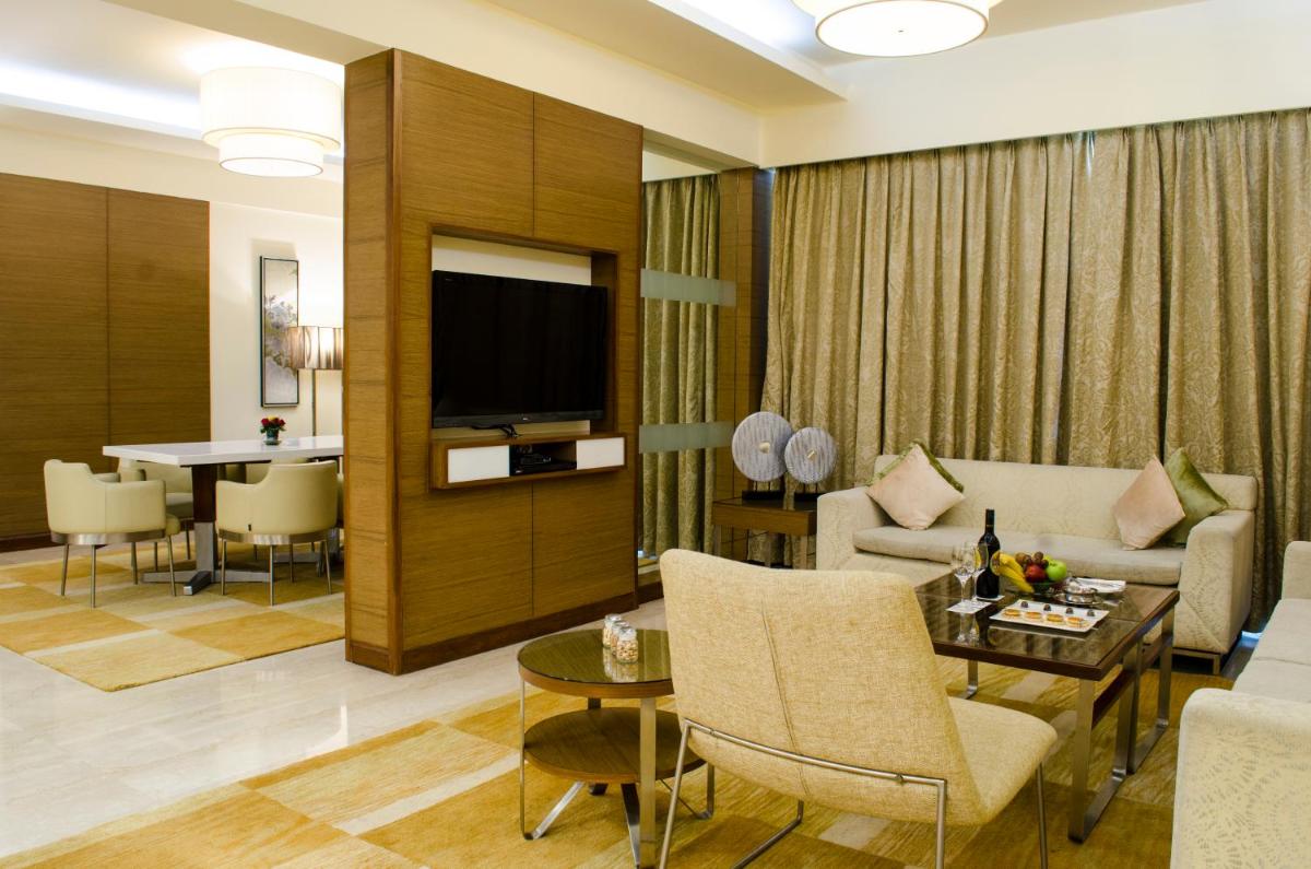 a living room with a couch and a table at Radisson Blu Hotel, Greater Noida in Greater Noida
