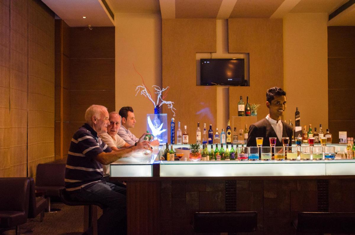 a group of men sitting at a bar at Radisson Blu Hotel, Greater Noida in Greater Noida