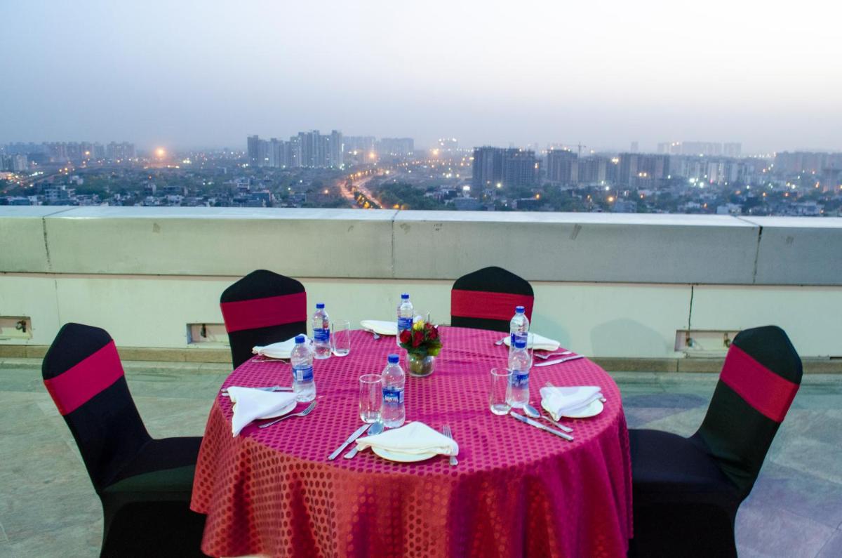 a table with a pink tablecloth and chairs with a view at Radisson Blu Hotel, Greater Noida in Greater Noida