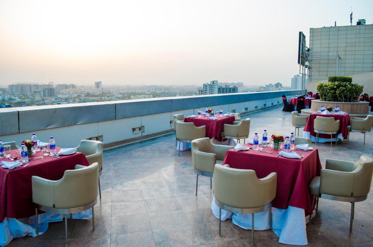 a restaurant with tables and chairs on a roof at Radisson Blu Hotel, Greater Noida in Greater Noida