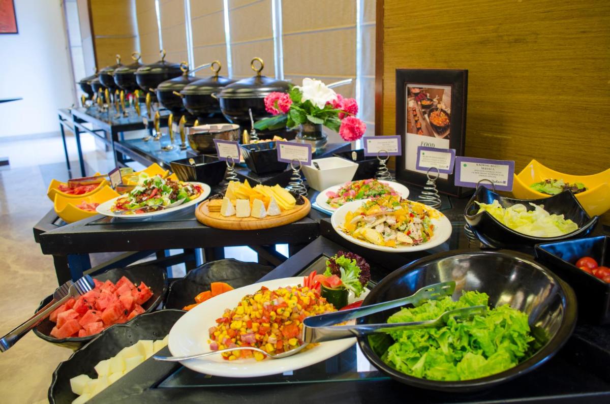 a buffet with many plates of food on a table at Radisson Blu Hotel, Greater Noida in Greater Noida