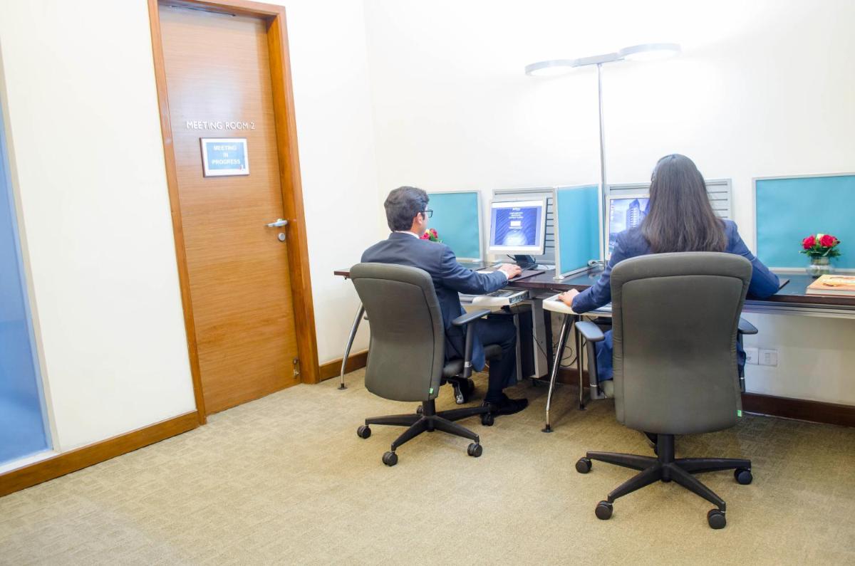 two people sitting at a desk in an office at Radisson Blu Hotel, Greater Noida in Greater Noida