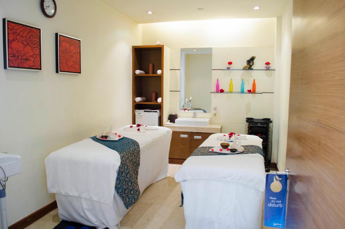 a room with two beds and a bathroom with a sink at Radisson Blu Hotel, Greater Noida in Greater Noida