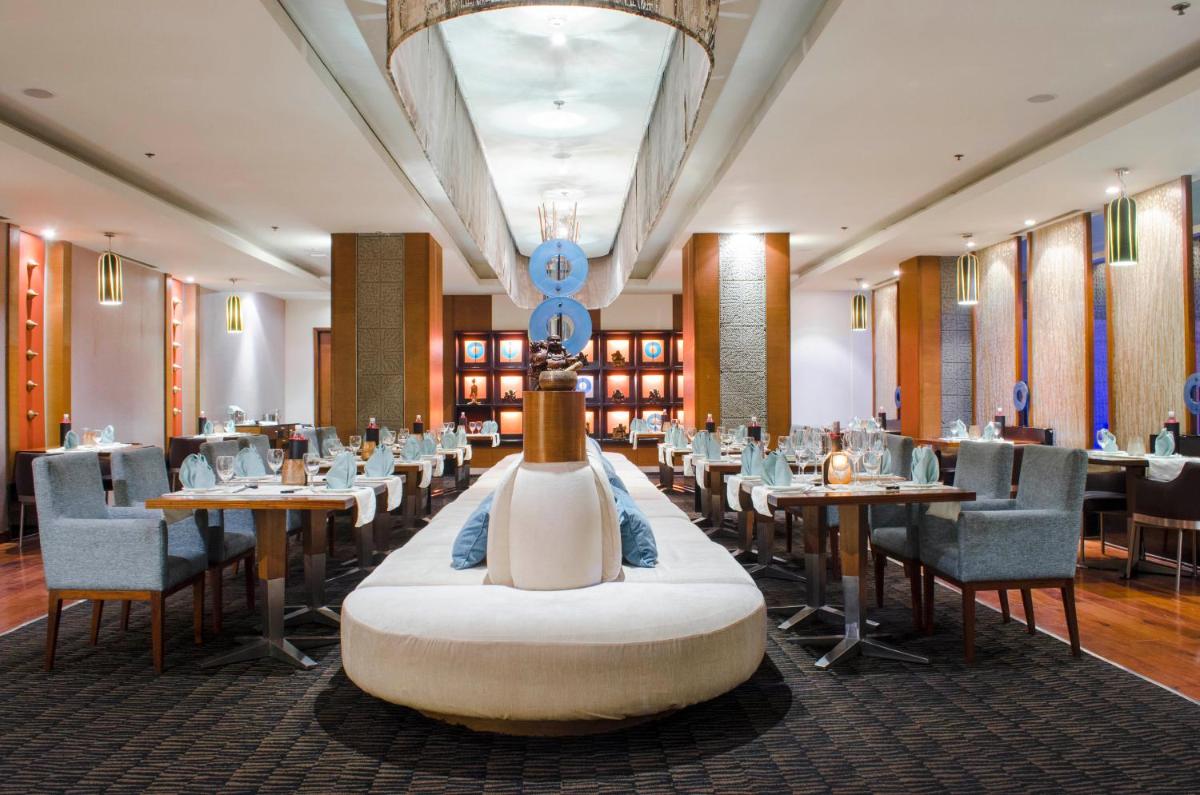 a dining room with tables and chairs and a centerpiece at Radisson Blu Hotel, Greater Noida in Greater Noida