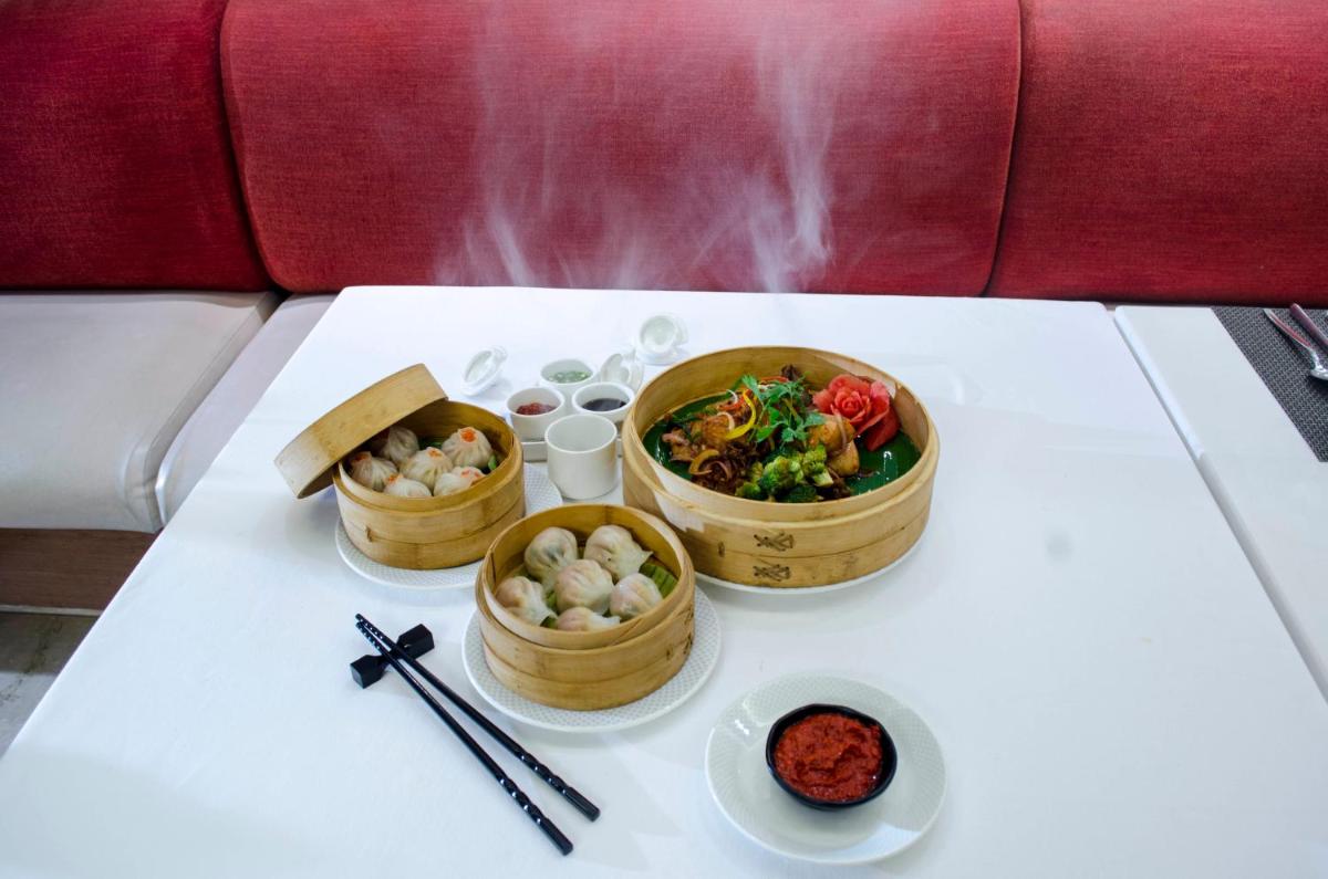 a table with three bowls of food and chopsticks at Radisson Blu Hotel, Greater Noida in Greater Noida