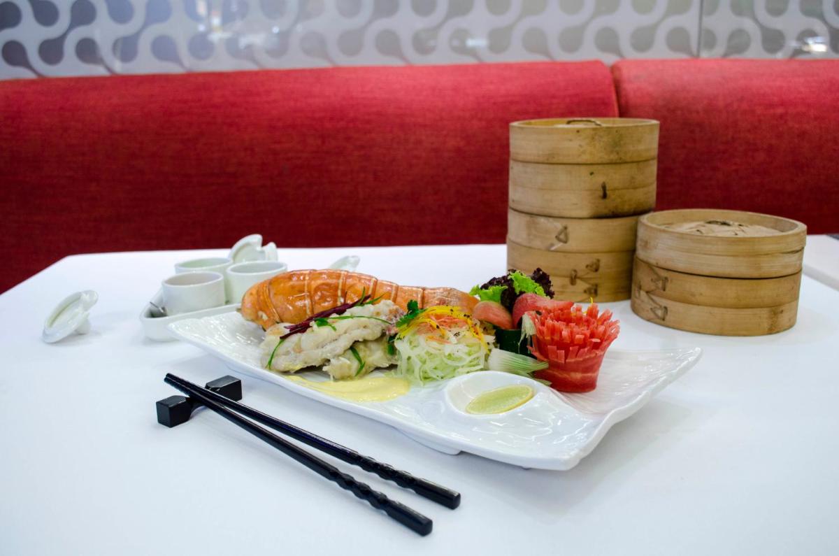 a plate of sushi and vegetables on a table at Radisson Blu Hotel, Greater Noida in Greater Noida