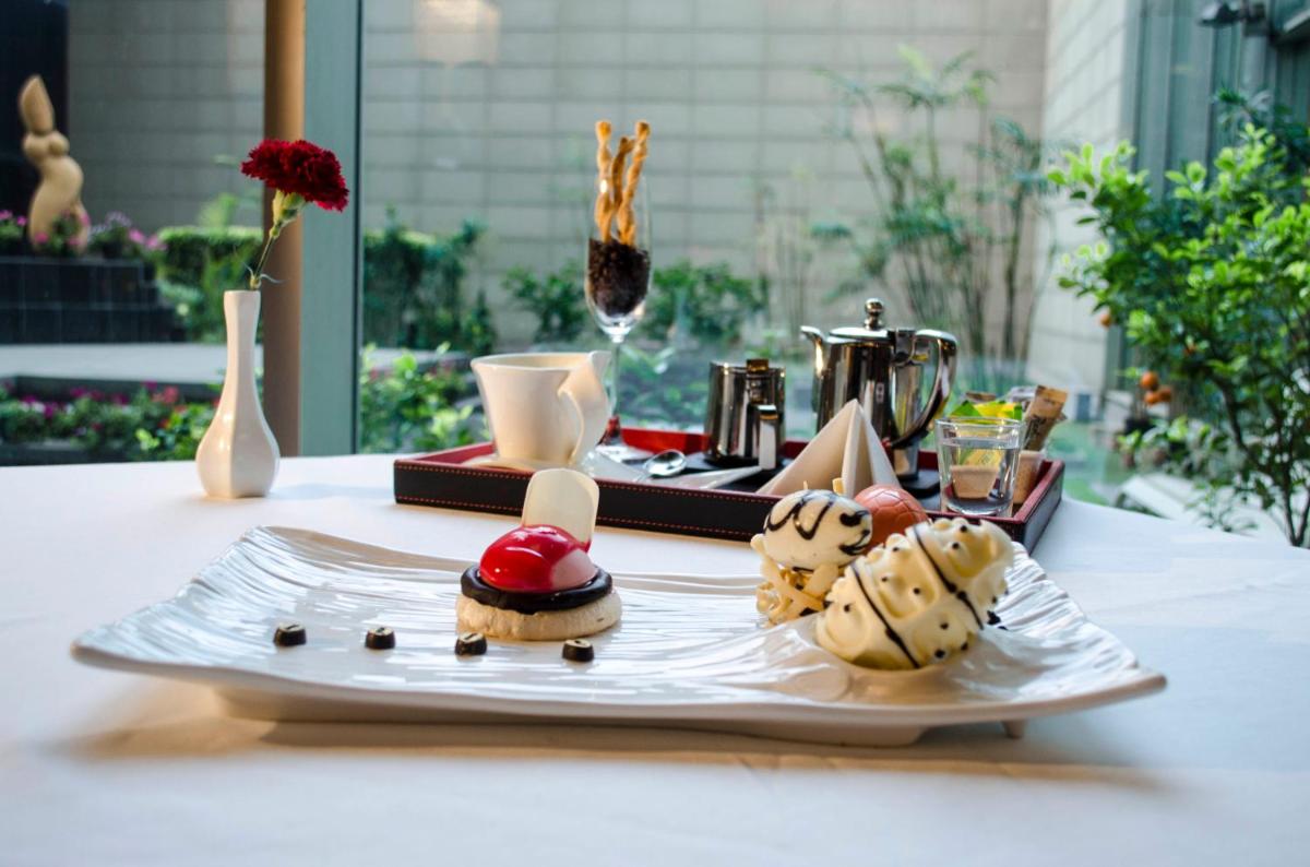 a plate with some food on a table at Radisson Blu Hotel, Greater Noida in Greater Noida