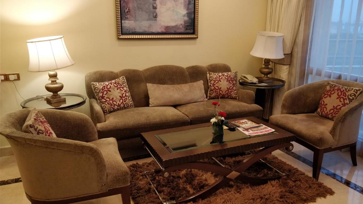 a living room with a couch and two chairs and a table at Jaypee Vasant Continental in New Delhi