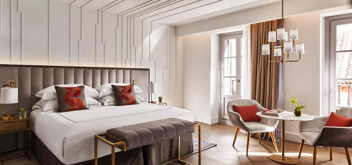 Un dormitorio con una cama y una mesa y sillas. en Gran Hotel Inglés - The Leading Hotels of the World, en Madrid