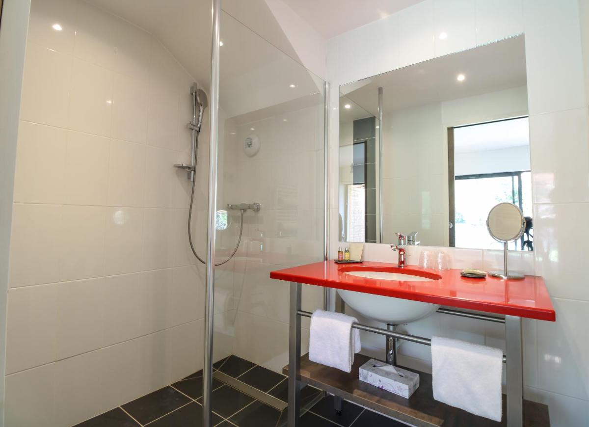 La salle de bains est pourvue d'un lavabo rouge et d'une douche. dans l'établissement Loire & Sens, à Juigné-sur-Loire