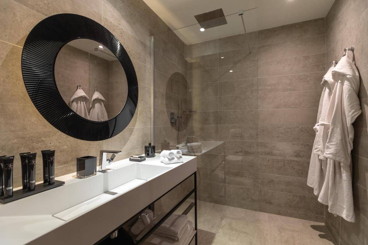 une salle de bain avec un lavabo et un miroir dans l'établissement Résidence & Spa Le Prince Régent, à Paris 24 autres photos