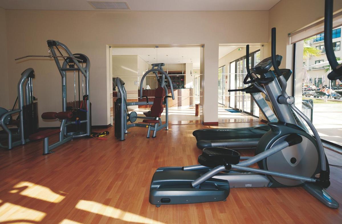 uma academia com esteiras e equipamentos de ginástica em uma sala em Vila Gale Santa Cruz em Santa Cruz - Madeira