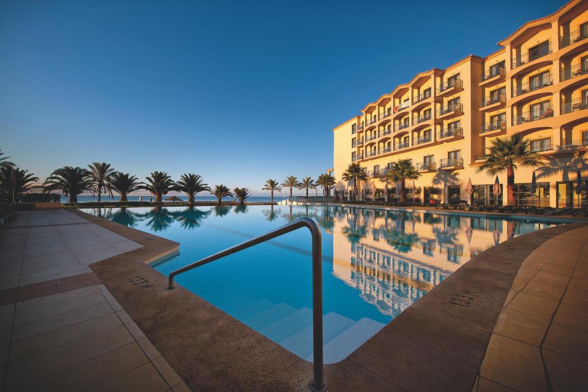 um hotel com piscina em frente a um prédio em Vila Gale Santa Cruz em Santa Cruz - Madeira