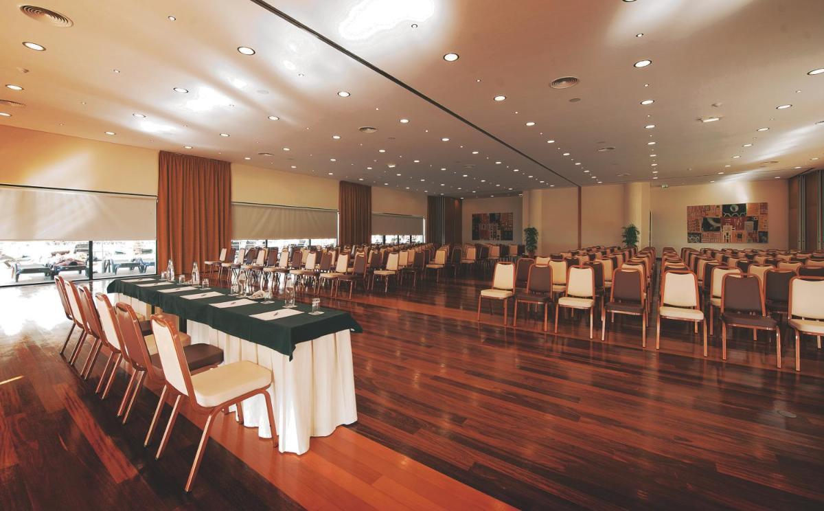 um salão de banquetes com uma mesa longa e cadeiras em Vila Gale Santa Cruz em Santa Cruz - Madeira mais 40 fotografias