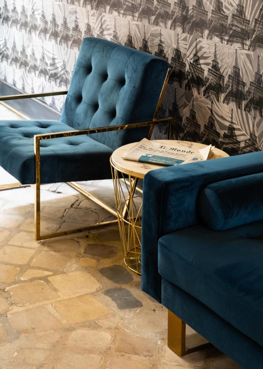 un salon avec deux chaises bleues et une table dans l'établissement Résidence & Spa Le Prince Régent, à Paris