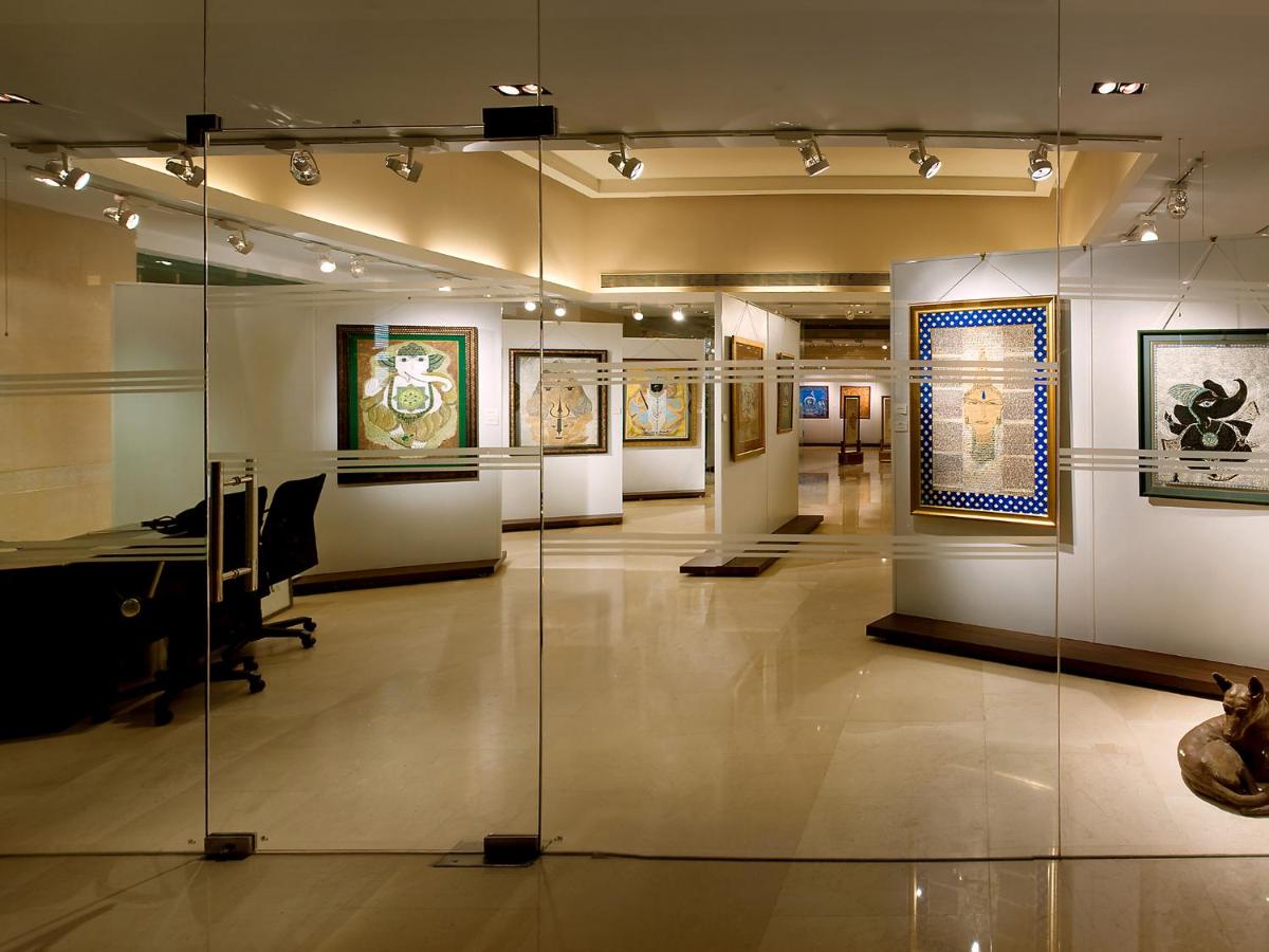 a museum with paintings on display in a room at The LaLiT New Delhi in New Delhi