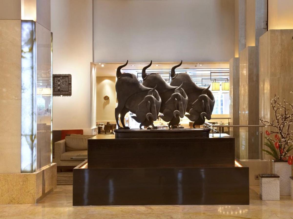 a statue of three horses in a lobby at The LaLiT New Delhi in New Delhi