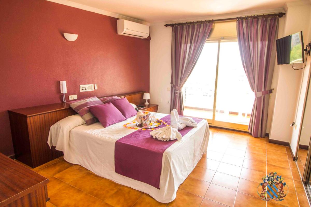 Un dormitorio con una cama grande con almohadas moradas. en Hotel Victoria Spa & Splay Center, en Segur de Calafell 62 fotos más
