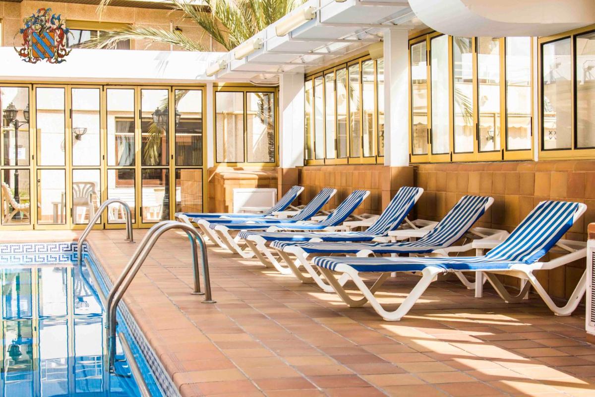 Una fila de tumbonas junto a una piscina. en Hotel Victoria Spa & Splay Center, en Segur de Calafell