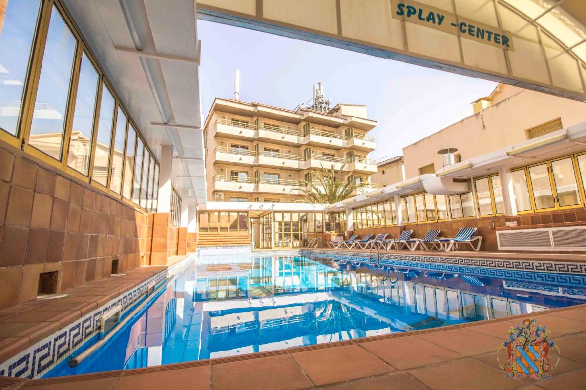 Una gran piscina en un edificio con un hotel. en Hotel Victoria Spa & Splay Center, en Segur de Calafell